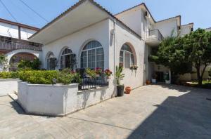 a white building with potted plants in a courtyard at Mironi & Victoria in Limenas