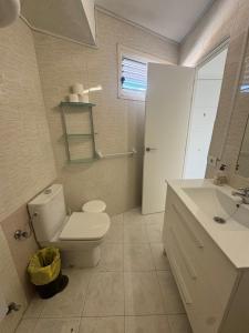 a bathroom with a white toilet and a sink at Casa climatizada in Playa Fañabe