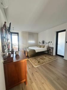 a bedroom with a bed and a table in a room at Azenha Ah Bô! in Alijó