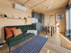 a living room with a green couch and a table at NORA Tiny House Bergheider See in Buschmühle