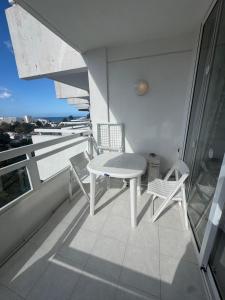 a balcony with a table and chairs on a building at Casa climatizada in Playa Fañabe