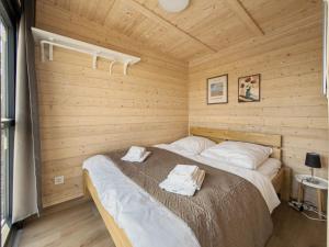 a bedroom with a bed in a wooden room at NORA Tiny House Bergheider See in Buschmühle