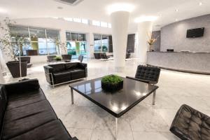 a lobby with couches and a table in a building at Favorita Golden Hotel e Eventos in São José