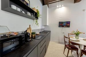 a kitchen with a counter top and a table at XX Settembre Studio Apartment in Parma +21 photos