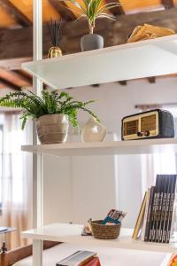 a white shelf with plants and a radio on it at XX Settembre Studio Apartment in Parma