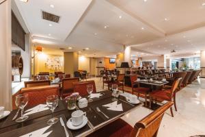 a restaurant with tables and chairs and a bar at Pestana Buenos Aires in Buenos Aires
