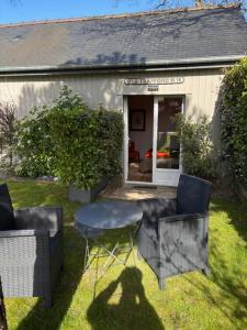 a table and chairs in front of a house at Les Mûres in Saint-Lunaire +2 photos