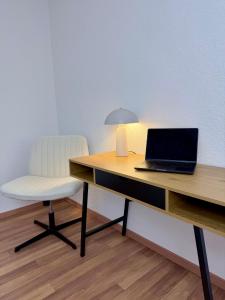 a desk with a laptop and a chair on it at Haus 87a Apartment 2 in Oberkirch