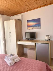 a bedroom with a desk with a computer and a bed at Qeparo Antonio Rooms in Qeparo