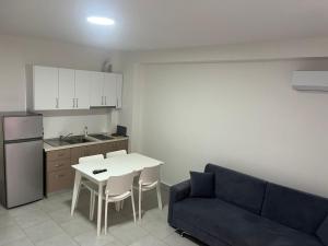 a living room with a couch and a table and a kitchen at BlueWaveapartments 4 in Shëngjin