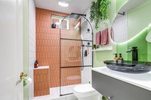 a bathroom with a sink and a glass shower at Midtown Oasis - BBQ, Deck, Games & Artistic Vibes in Sacramento +24 photos