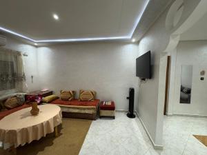a living room with a couch and a tv at Lixus Appartement- 1h Stadion & Airport Tanger in Larache