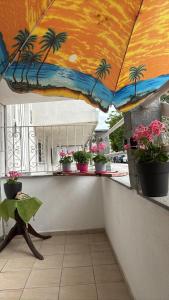 a balcony with potted plants and an umbrella at Sofies Studio in Nea Peramos
