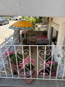 a balcony with an umbrella and potted plants at Sofies Studio in Nea Peramos