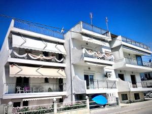 a white apartment building with people on the balconies at Sofies Studio in Nea Peramos