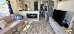 a living room with a couch and a flat screen tv at Blue Lagoon Holiday ,Bude 79 in Cubert