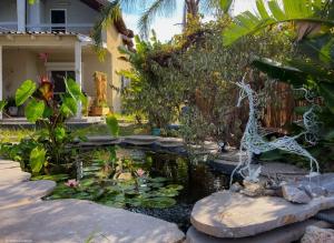 a pond in front of a house with a garden at Home for Air -- 9 minutes from sea of Galilee in Giv'at Yo'av