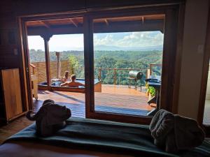 a room with a view of a deck with a hot tub at Cliffhanger Cottages in Rheenendal +2 photos