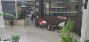 a lobby with a red and white chair in a building at The Savannah Hotel, Garki in Abuja +24 photos