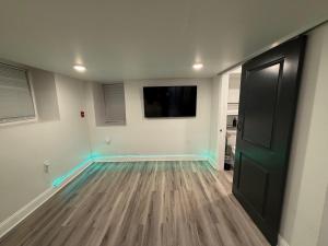 an empty room with a flat screen tv and a door at Cozy Modern Studio in Philadelphia
