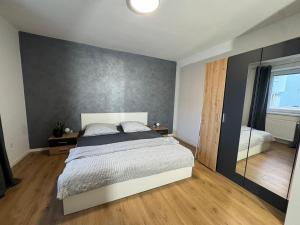 a bedroom with a large bed and a wall at Apartmán Zamarovce in Trenčín