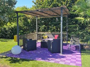 a gazebo with chairs and a couch on a purple blanket at Le Maillotin en balade in Les Maillys