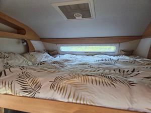 a large bed with white sheets and leaves on it at Le Maillotin en balade in Les Maillys +3 photos