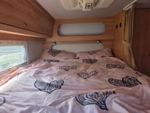 a bed with hearts drawn on it in an rv at Le Maillotin en balade in Les Maillys