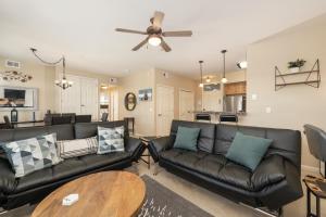 a living room with black leather couches and a table at 175 Spinner 5-2 in Fraser