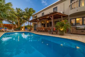 a swimming pool in front of a house at Oasis guesthouse, Boutique Style Hotel in Kralendijk