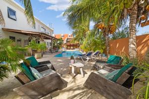 a resort with a swimming pool and palm trees at Oasis guesthouse, Boutique Style Hotel in Kralendijk