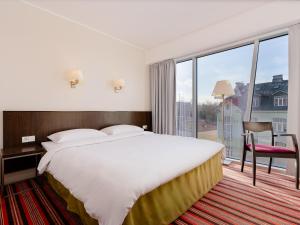 a hotel room with a bed and a large window at Park Inn by Radisson Meriton Conference & Spa Hotel Tallinn in Tallinn