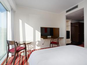 a bedroom with a bed and a table and chairs at Park Inn by Radisson Meriton Conference & Spa Hotel Tallinn in Tallinn