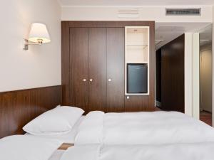 a bedroom with two white beds and a tv at Park Inn by Radisson Meriton Conference & Spa Hotel Tallinn in Tallinn