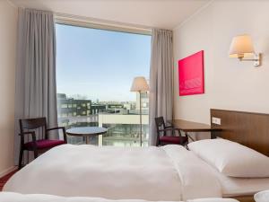 a hotel room with a bed and a large window at Park Inn by Radisson Meriton Conference & Spa Hotel Tallinn in Tallinn +179 photos