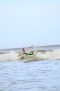 a person riding a wave on a surfboard in the ocean at Panama Beach Lodge in San Carlos