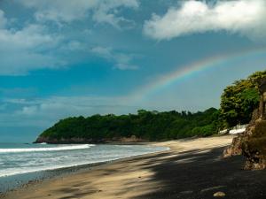a beach with a rainbow in the sky at Panama Beach Lodge in San Carlos +67 photos