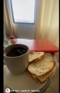 a plate with a sandwich and a cup of coffee at Casa Artesana Maras URU CUZ PE in Maras