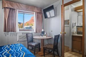 a bedroom with a bed and a table and chairs at Travelodge by Wyndham Kanab in Kanab