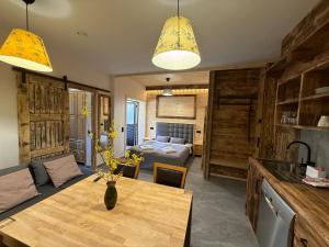 a kitchen and living room with a table and a bedroom at Apartament Rodzinny Deluxe in Poronin