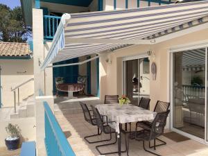 a dining table under an awning on a patio at Villa Rose in Seignosse