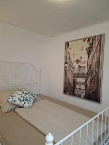 a bedroom with a bed with a picture on the wall at Ferienwohnung Zeit für Meer in Kruså
