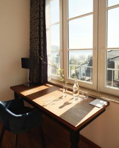 a wooden table sitting in front of a window at VILLA LINDE Seehotel in Bodman-Ludwigshafen +81 photos