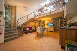 a living room with a staircase and a table and chairs at My Tuscany Suites in Castiglioncello