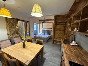 a living room with a table and a bedroom at Apartament Rodzinny Deluxe in Poronin