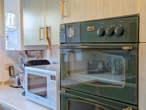a green oven in a kitchen with a microwave at Thimble Cottage - Emsworth in Emsworth +16 photos