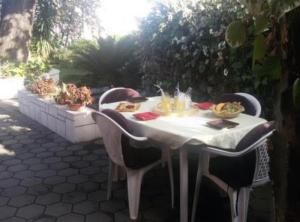 a white table with chairs and food on it at Apartmani Borić in Orebić