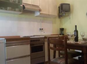 a kitchen with a stove and a table with wine glasses at Apartmani Borić in Orebić +14 photos