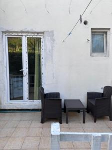 a patio with chairs and a table and a window at Green Villa in Šušanj