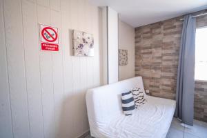 a white couch in a room with a sign on the wall at Edificio Prieto VIV 5 in Puerto del Rosario